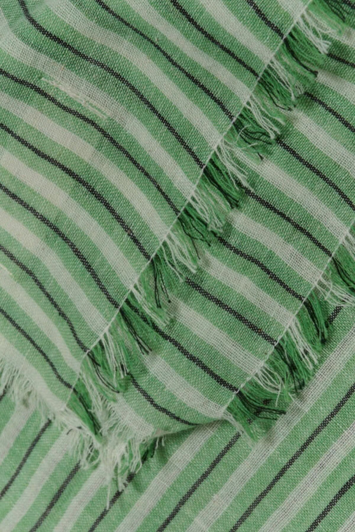 Foulard rayé Sofi en coton léger avec franges vert et noir, détails de texture et motifs striés.