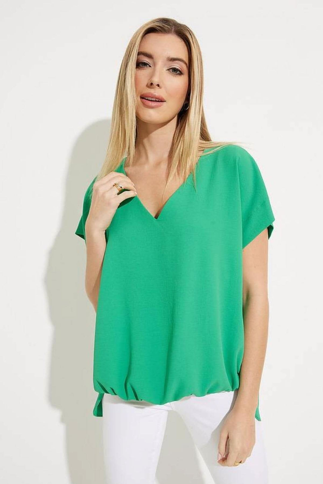 Haut asymétrique vert encolure en V, manches tombantes et ourlet froncé, style décontracté.