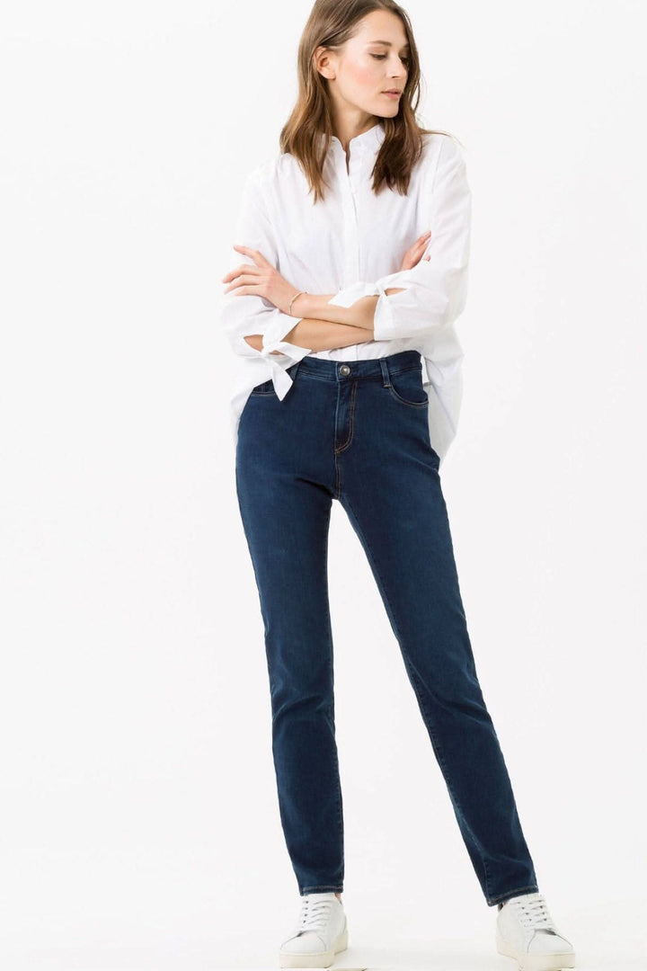 Femme portant le jean Mary, coupe décontractée, en denim authentique, avec une chemise blanche élégante.