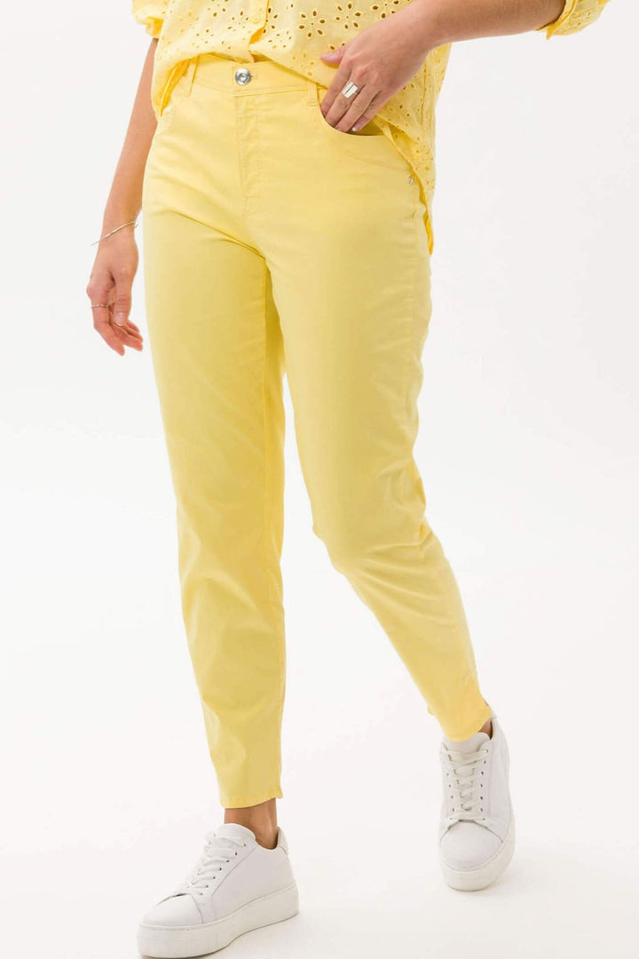 Femme portant un pantalon jaune slim avec blouse, offrant un look tendance et élégant.