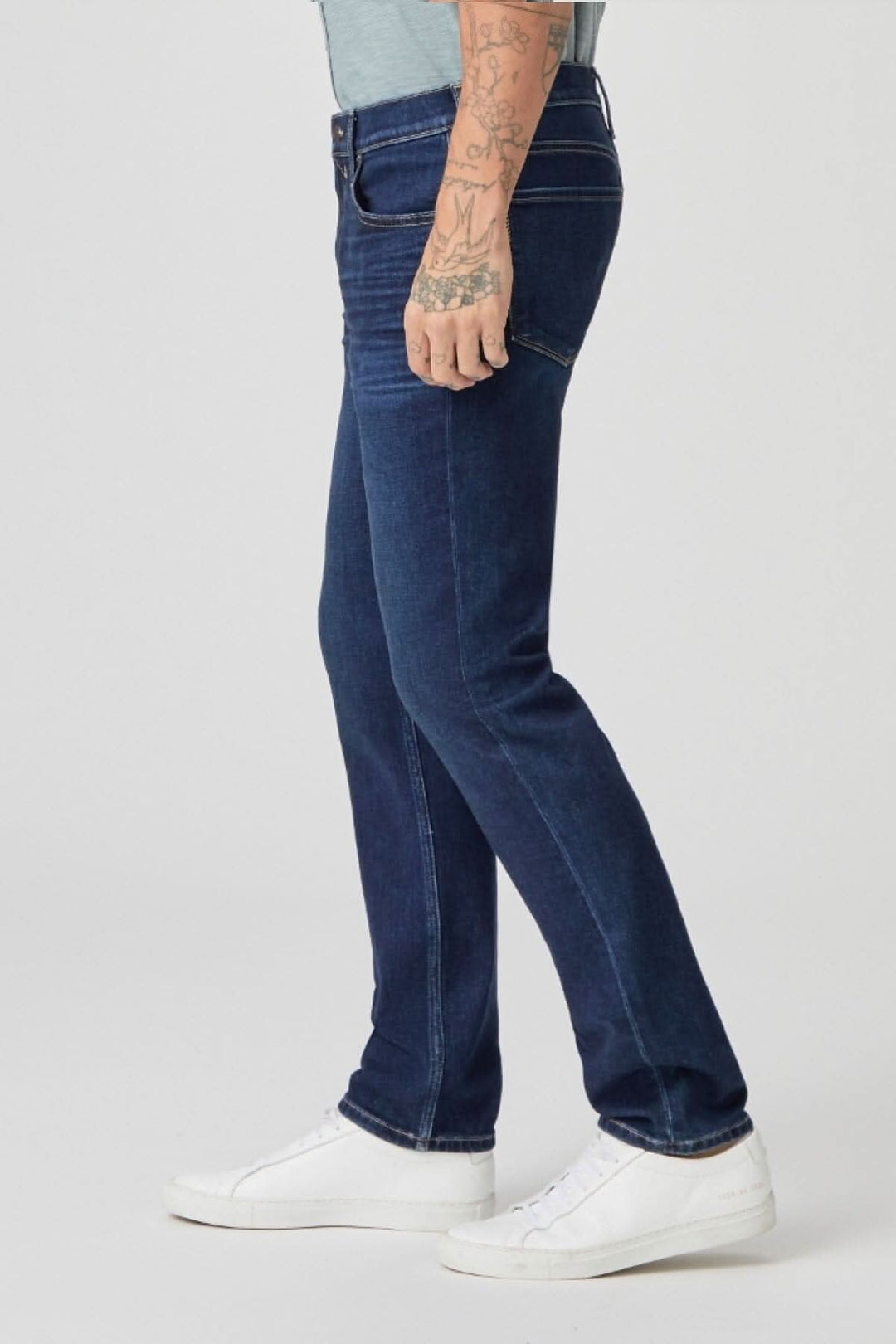 Jeans Lennox Danfrey en délavage foncé, coupe étroite, porté par un homme avec des baskets blanches.
