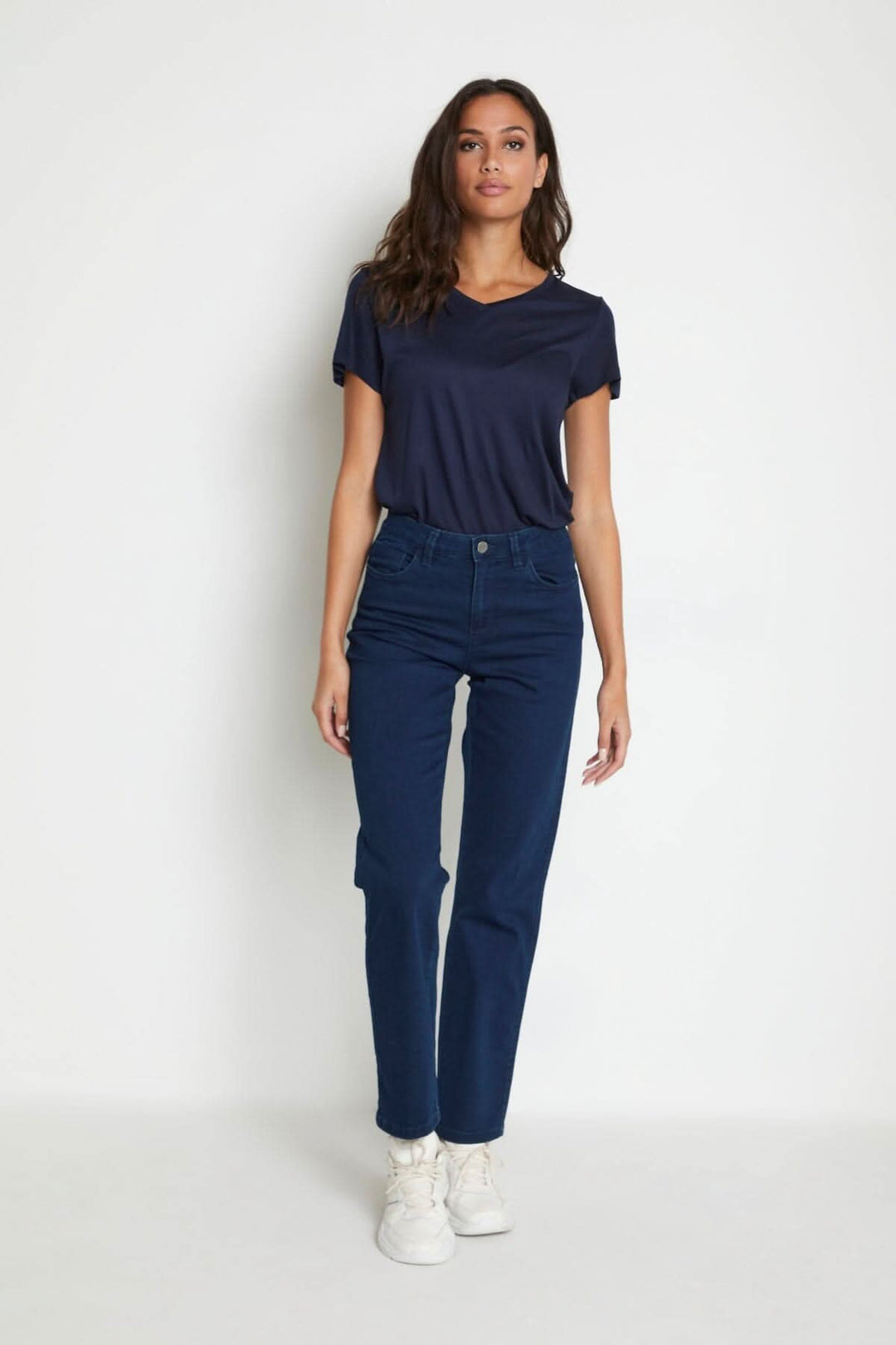 Femme portant des jeans Vicky bleu avec un haut marine, style régulier et coupe cinq poches.