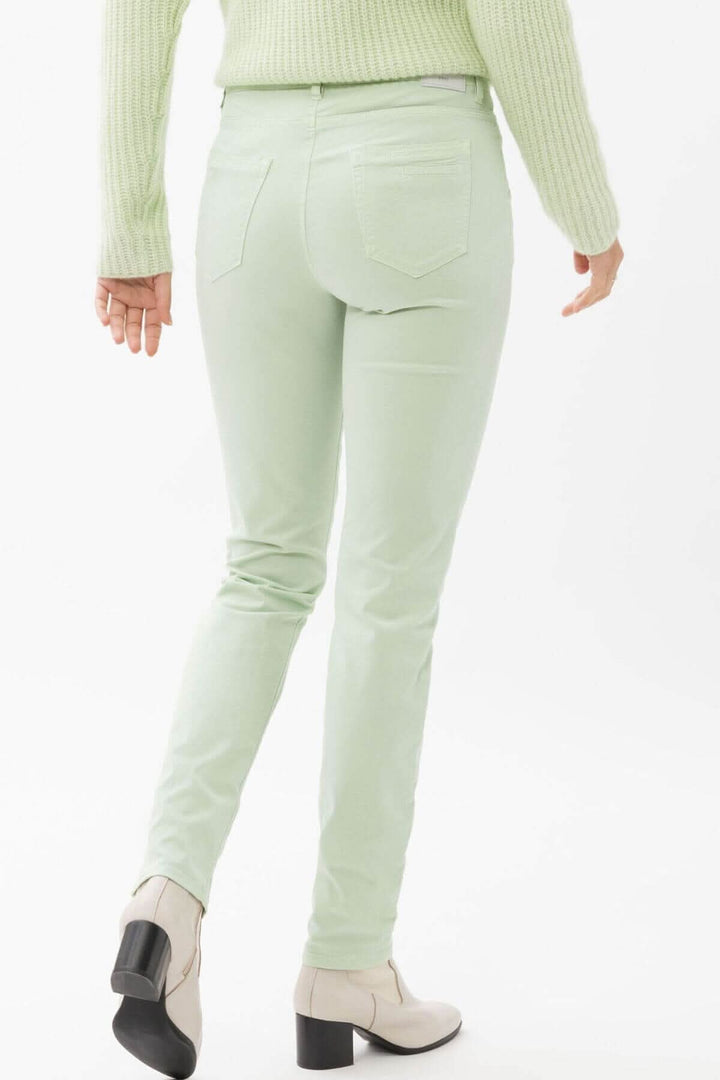 Pantalon de coupe skinny couleur vert clair, vue arrière, style sportif pour femme, porté avec des bottines.