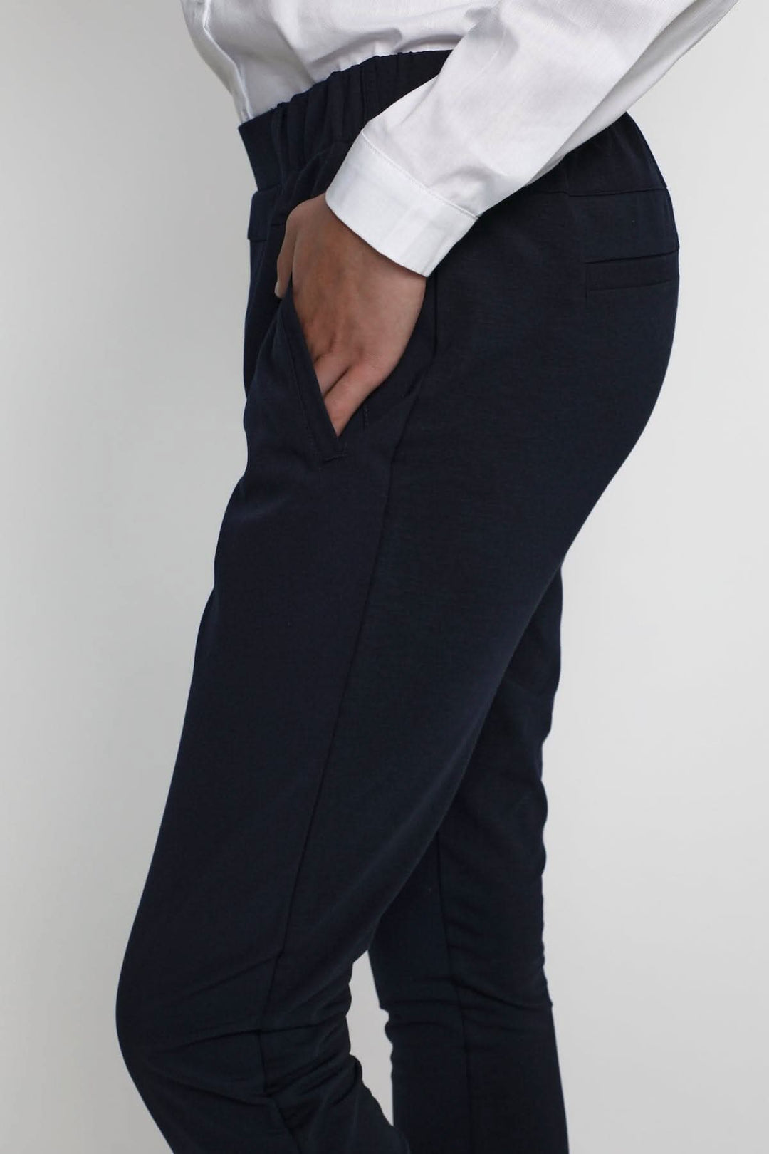 Pantalon de tailleur Jillian Sofie, chic et confortable, avec poches et coupe régulière, porté avec une chemise blanche.