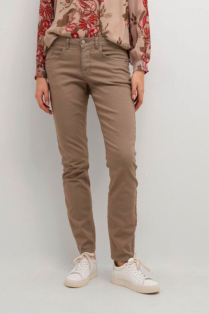 Pantalon style jean étroit en coton, polyester et élasthanne, confort exceptionnel, porté avec un haut fleuri.