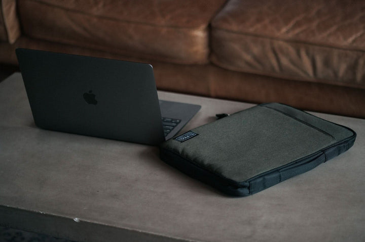 Pochette PKG Stuff pour ordinateur portable avec un laptop sur une table en bois.