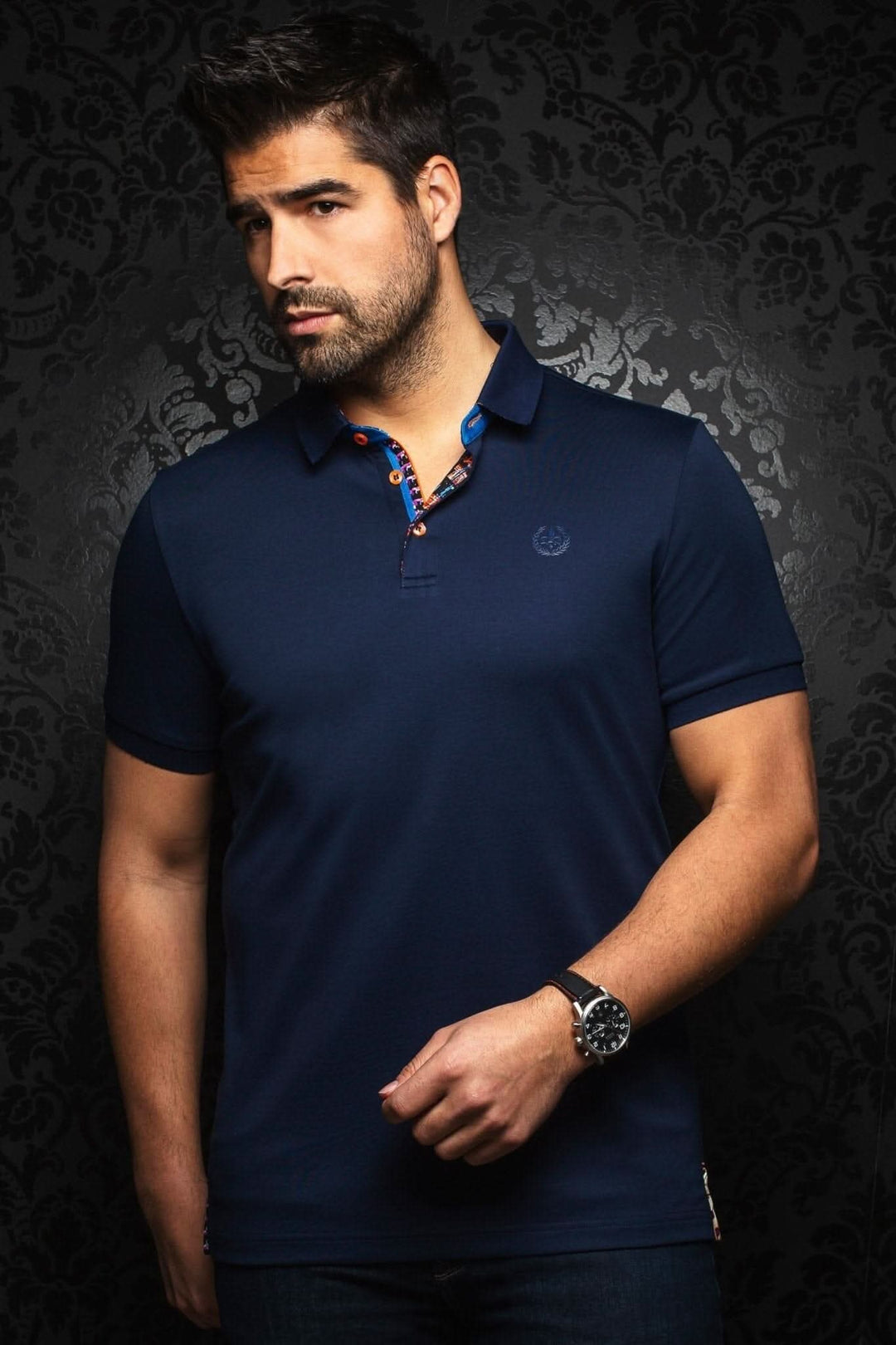 Homme portant un polo marine au col contrastant, style habillé et décontracté, tissu en coton haut de gamme.