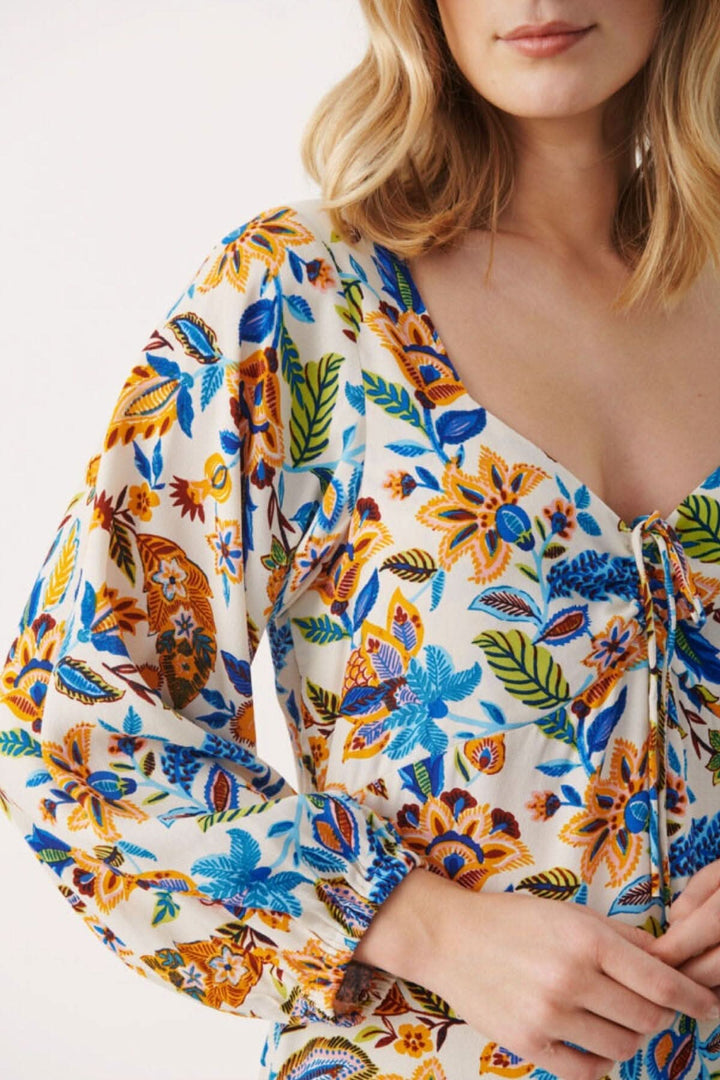 Robe fleurie Samira, manches longues à volants, décolleté avec cordon, motif floral coloré.