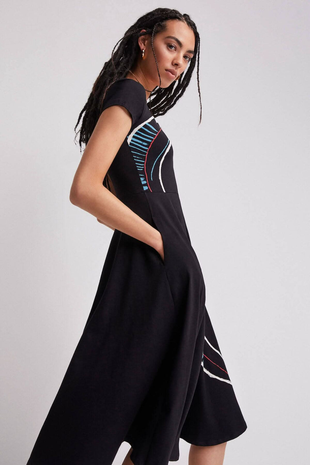 Robe longue noire à imprimé artistique, coupe trapèze et manches courtes, présentée sur un mannequin.
