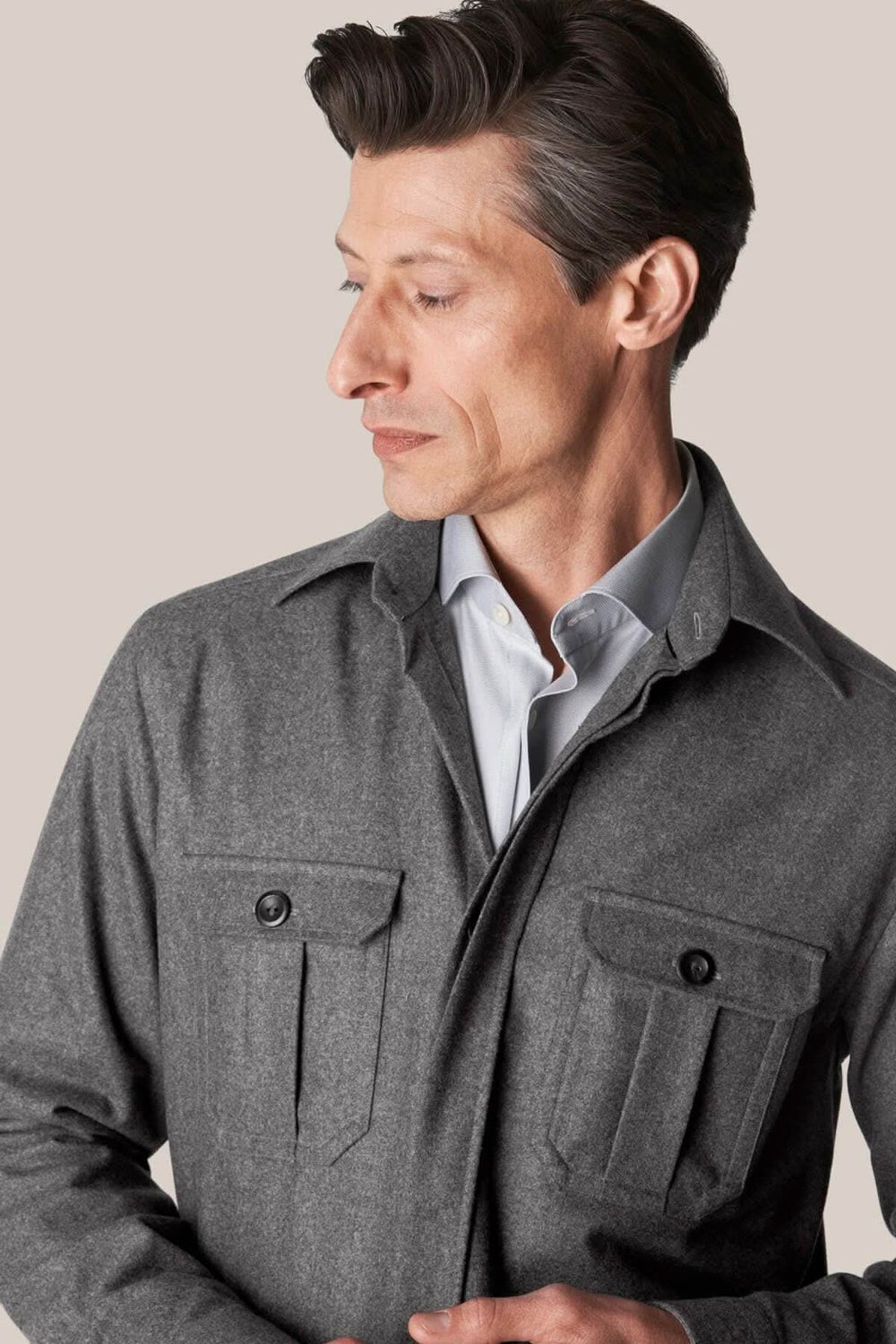 Homme portant une surchemise en laine cachemire grise avec poches, style sophistiqué et décontracté.