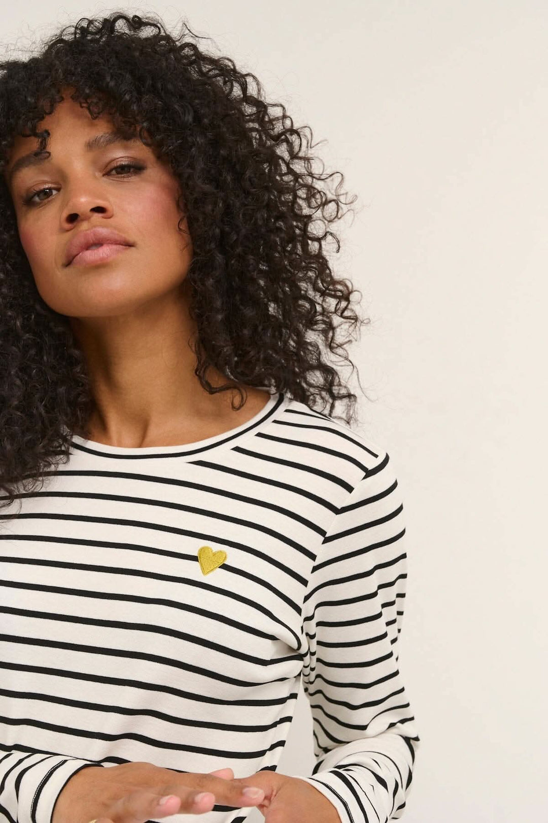 T-shirt à manches longues rayé avec cœur cousu sur la poitrine, modèle Lidy, femme en photo.