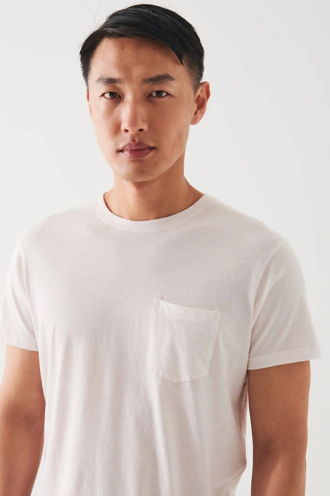 Homme portant un t-shirt léger en coton pima avec poche, idéal pour temps chaud.