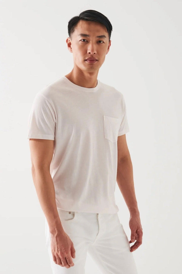 Homme portant un t-shirt léger en coton pima avec poche, style décontracté, parfait pour temps chaud.