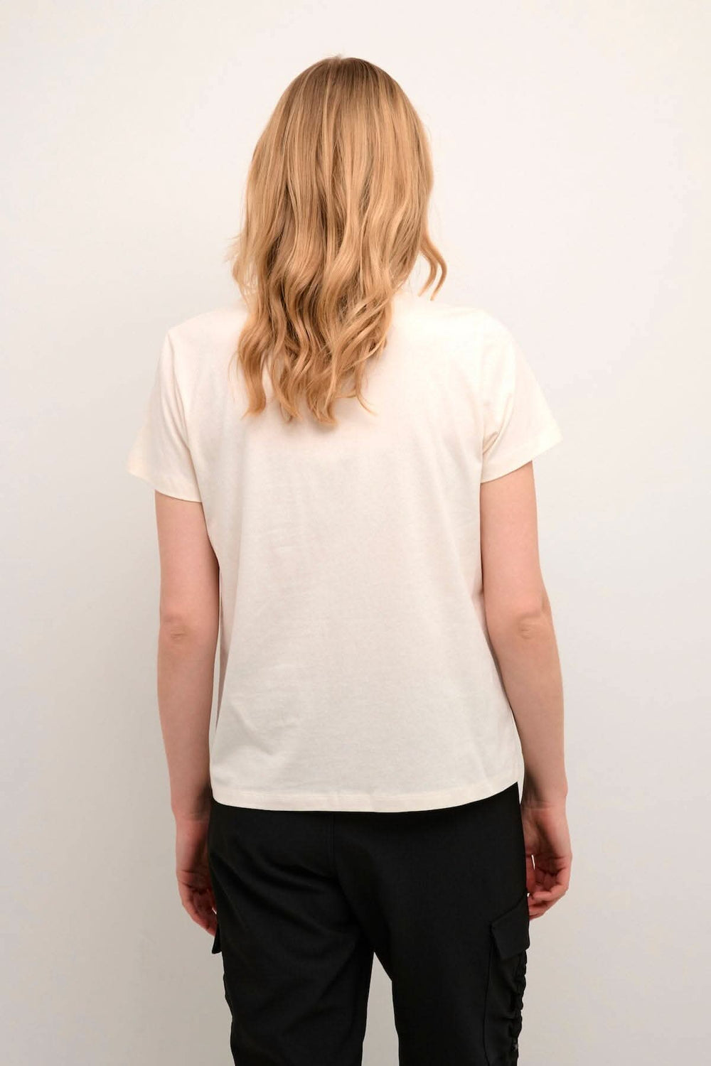 Vue arrière d'un t-shirt Rinne avec encolure ronde et coupe régulière, porté avec un pantalon noir.