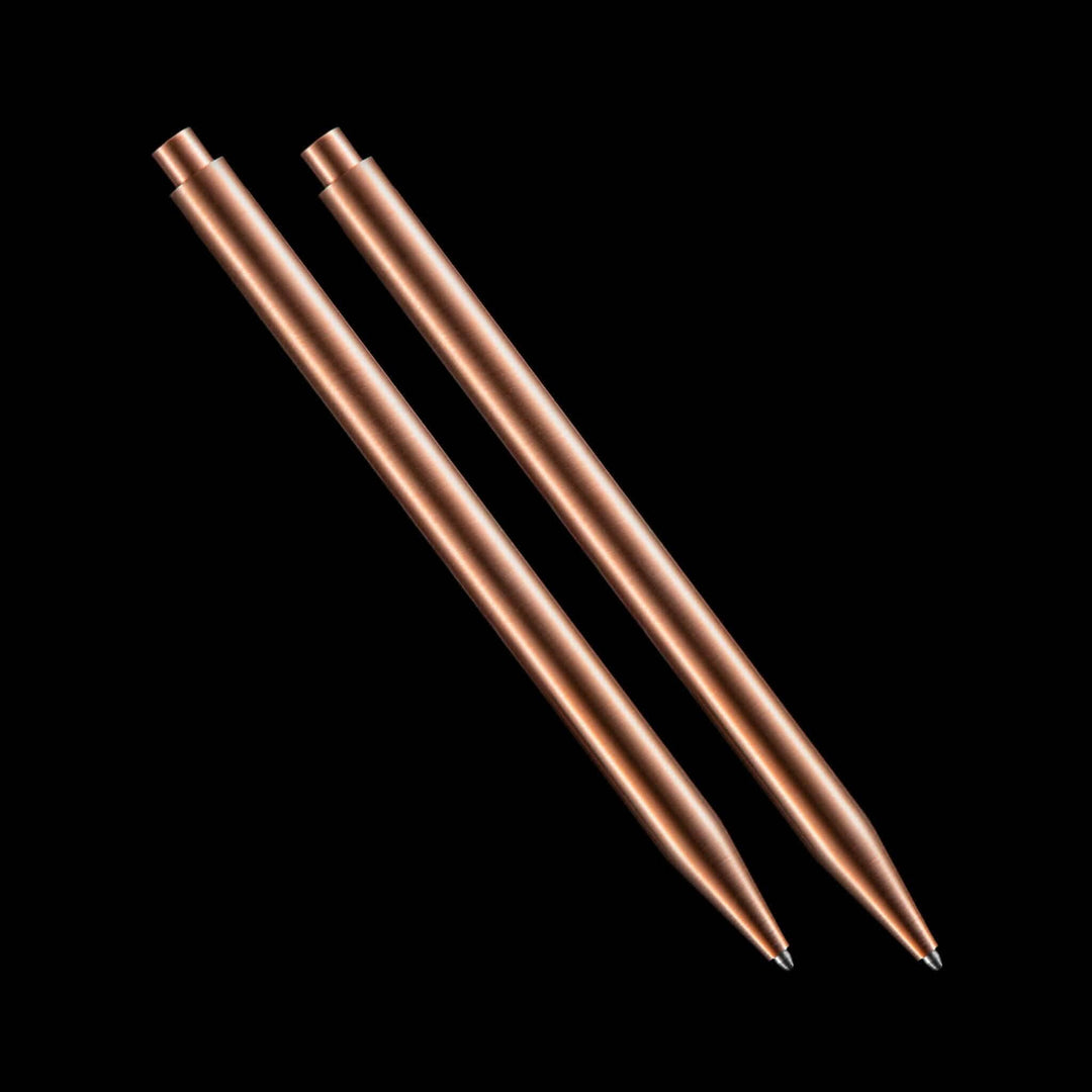 Deux stylos modernes en cuivre sur fond noir, parfaits pour une écriture élégante et contemporaine.