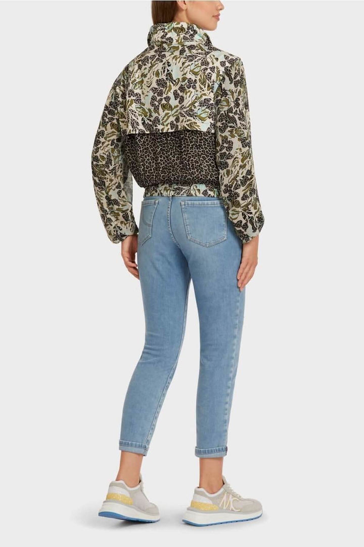 Veste féminine à motifs patchwork avec col montant, portée avec un jean bleu et des baskets, vue arrière.