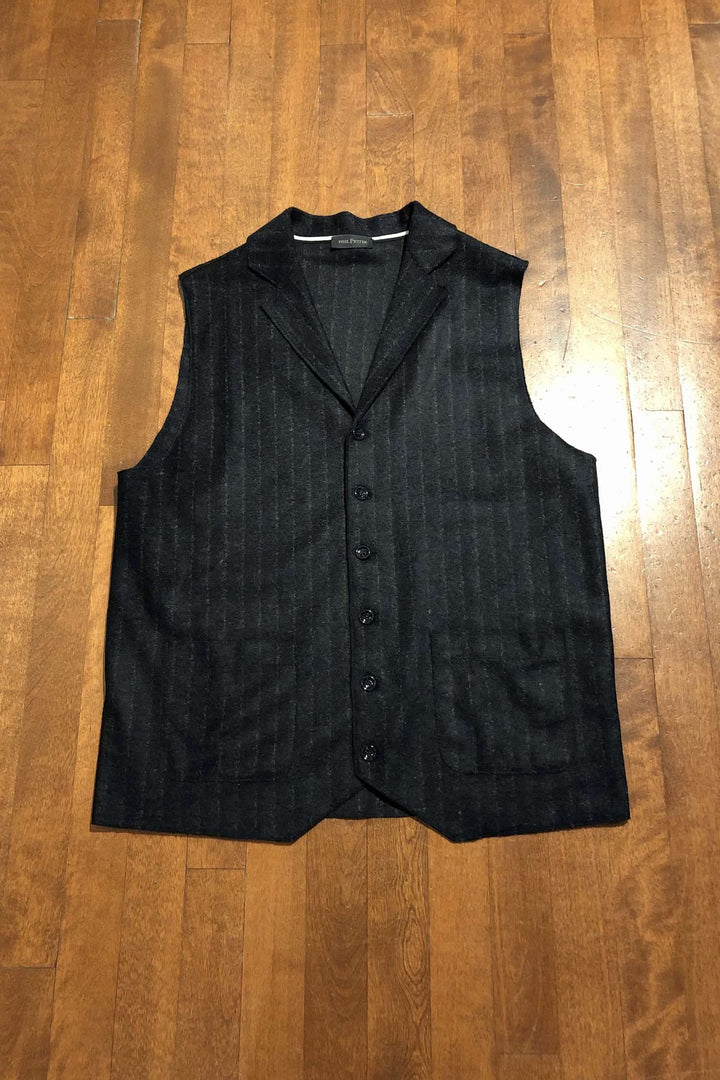 Veste sans manches marine à rayures grises, avec boutons et col, sur un fond en bois.